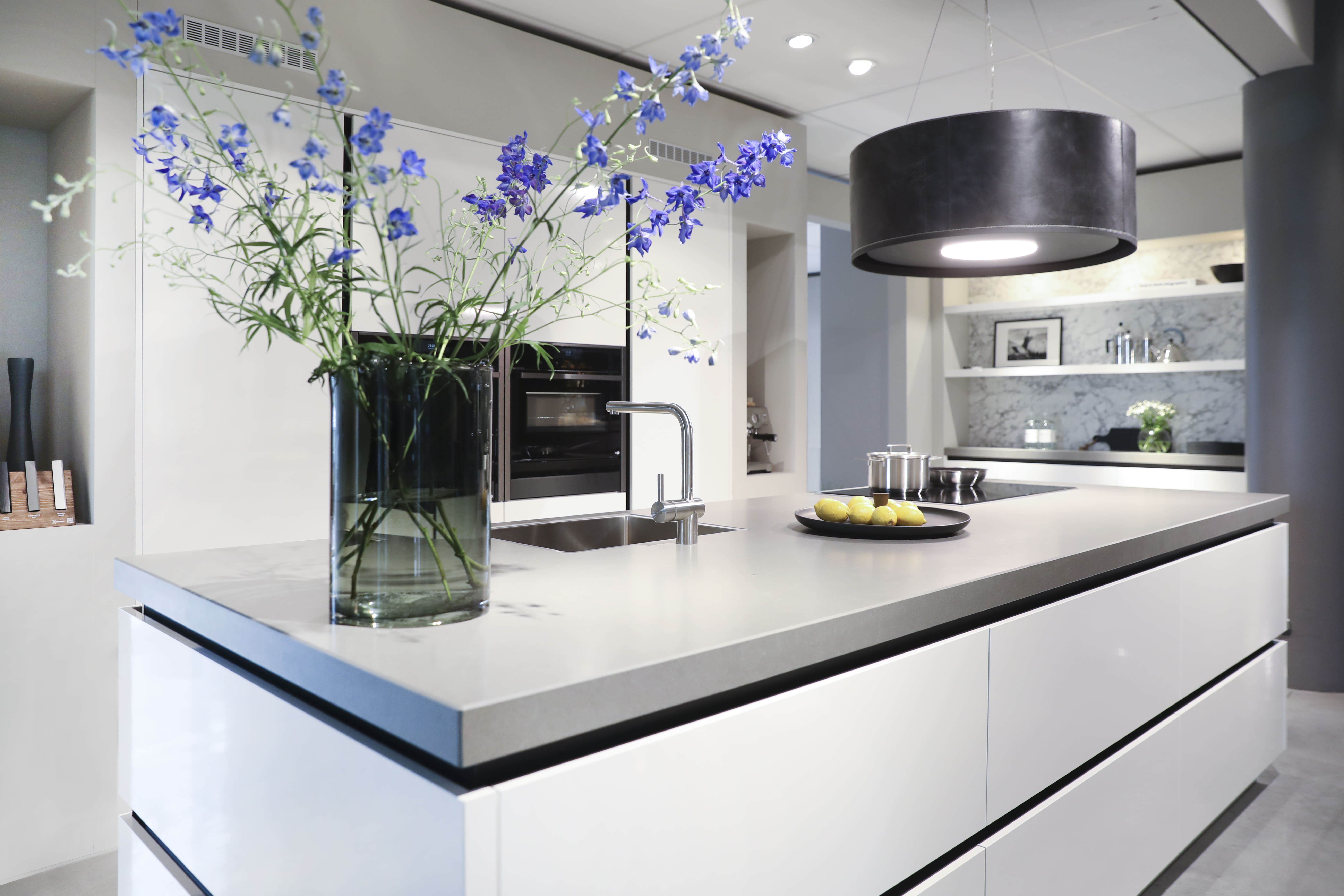 Witte keuken met kookeiland en grijs werkblad